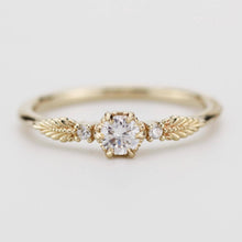 Load image into Gallery viewer, This beautiful vintage engagement ring showcases a round diamond in the center, with two smaller diamonds on the sides. Made from 18k gold, it perfectly blends classic elegance with a modern touch.