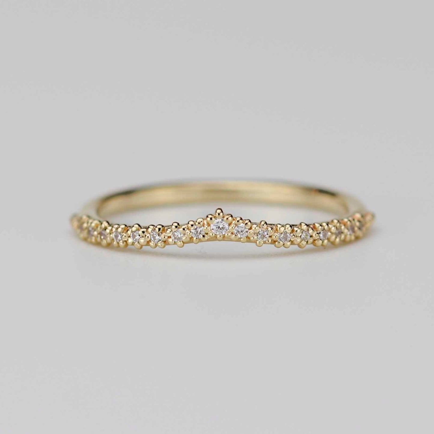 18k yellow gold chevron wedding band with 17 diamonds in a beaded crown tiara setting on a white background.