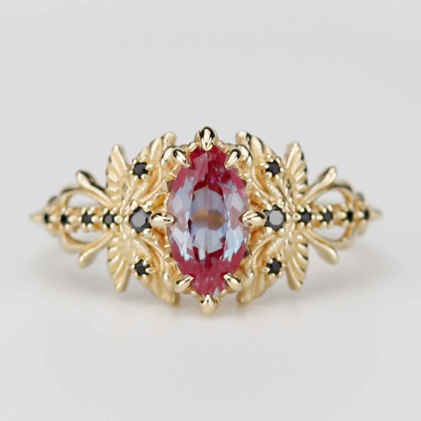 18k yellow gold dragonfly ring featuring a marquise-cut lab alexandrite center stone and black diamond accents on a white background.