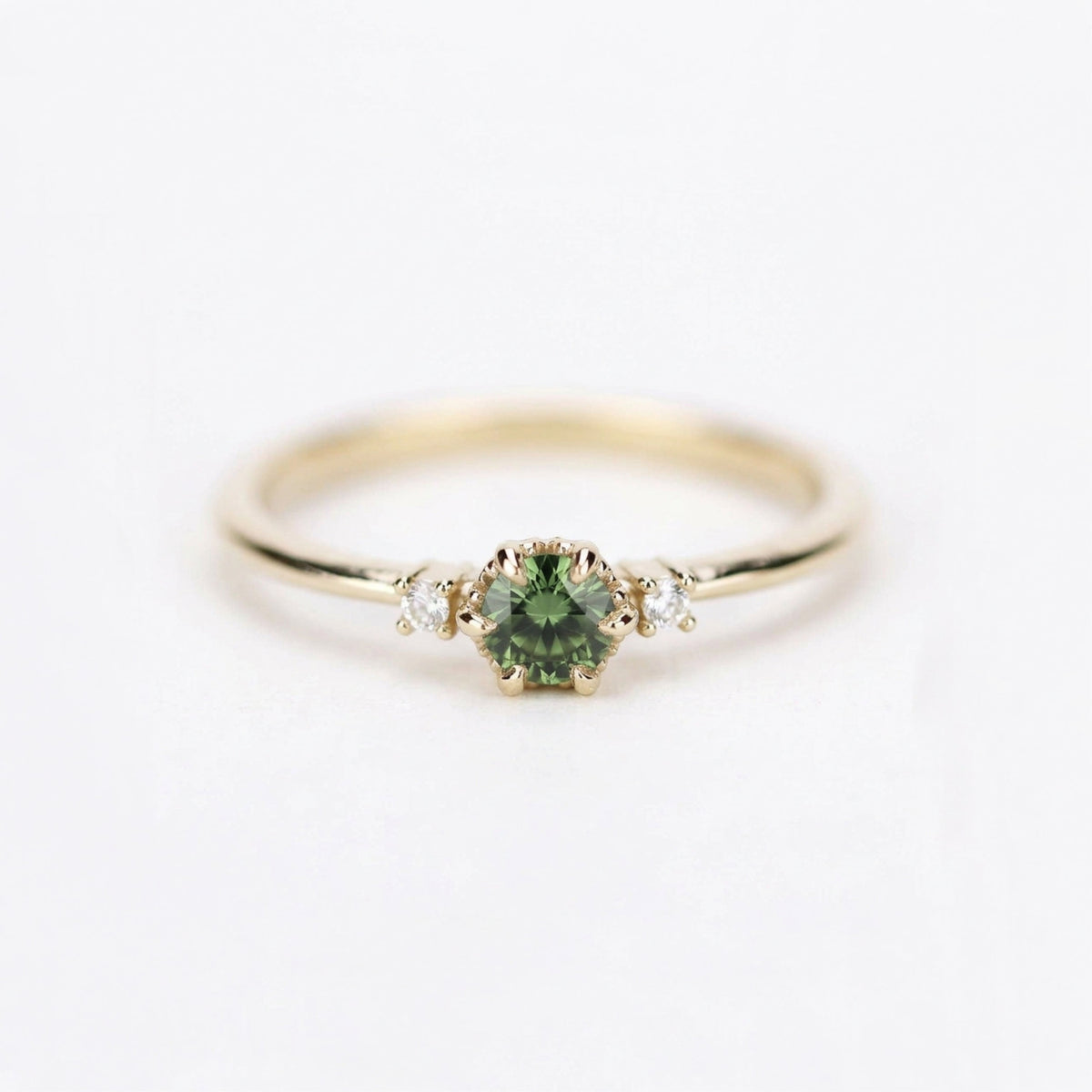 Yellow gold three-stone petal ring with a round green sapphire and two diamonds, front view