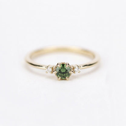 Yellow gold three-stone petal ring with a round green sapphire and two diamonds, front view