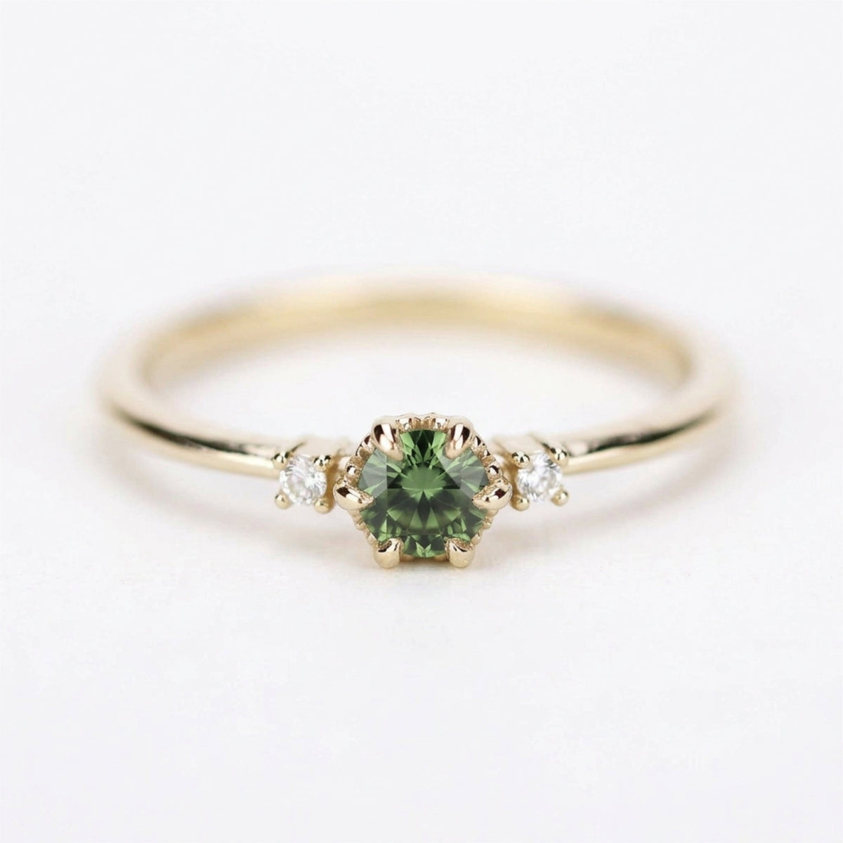 Yellow gold three-stone petal ring with a round green sapphire, straight front on white