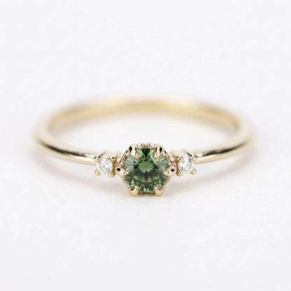 Yellow gold three-stone petal ring with a round green sapphire, straight front on white