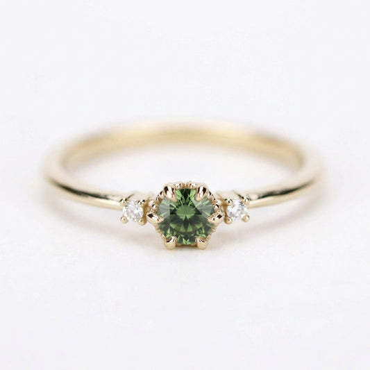 Yellow gold three-stone petal ring with a round green sapphire, straight front on white