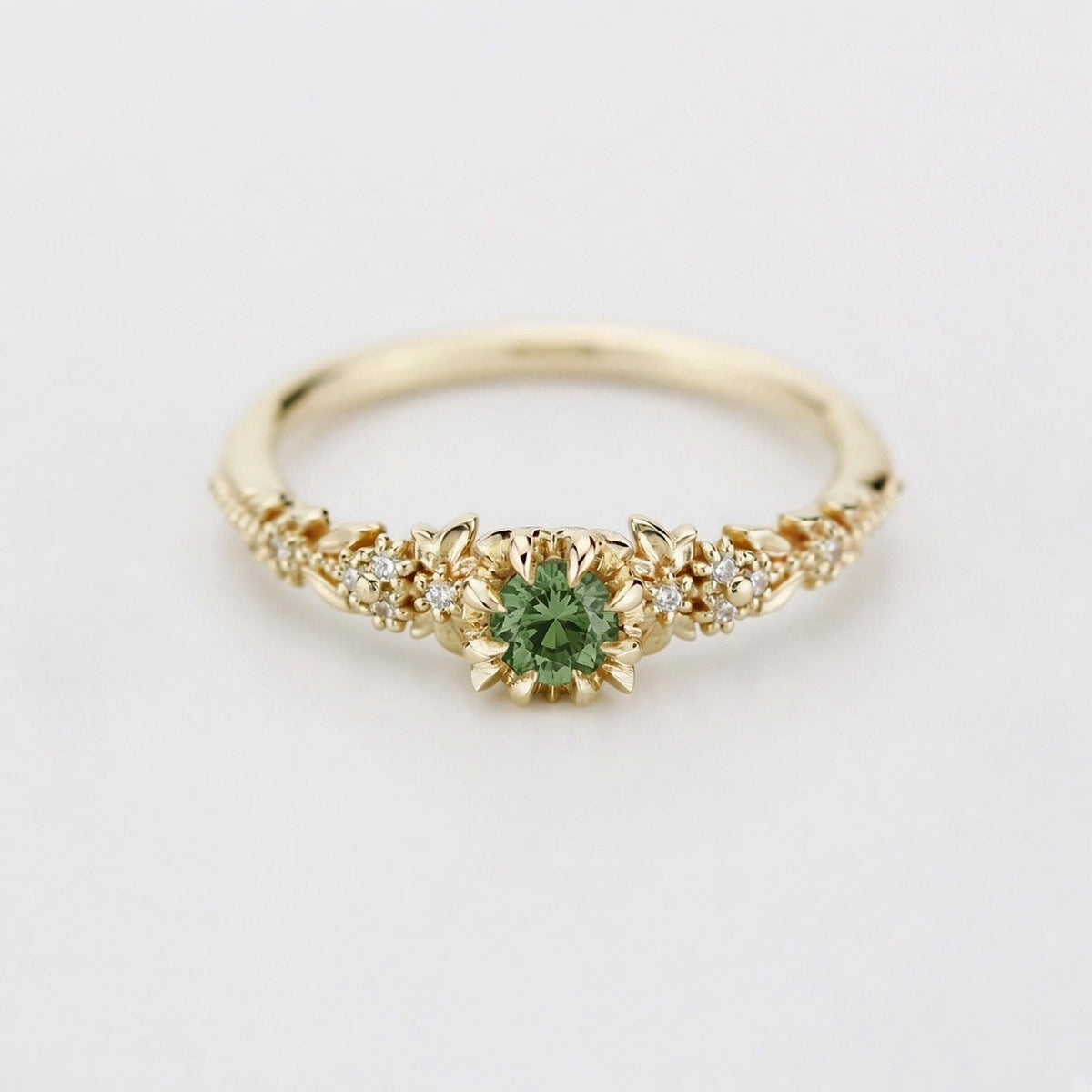 Yellow gold floral engagement ring with a round green sapphire and white diamonds