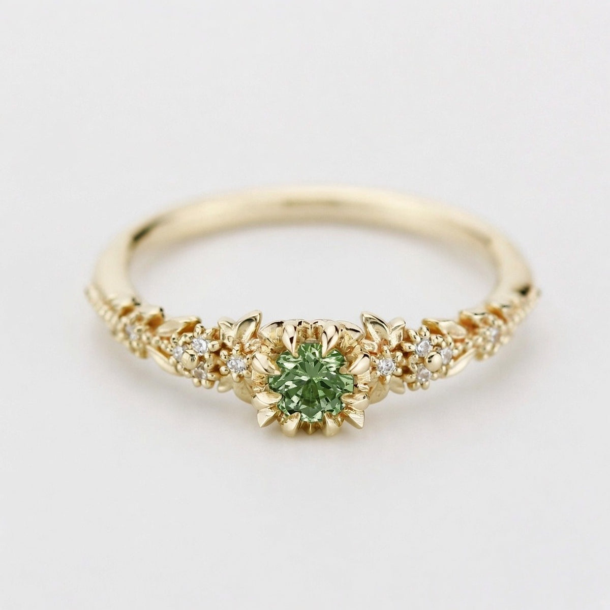 Yellow gold floral engagement ring with a round green sapphire and white diamonds