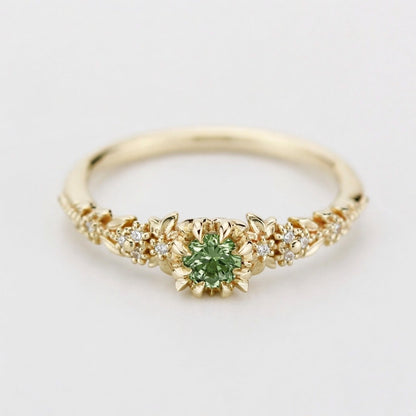Yellow gold floral engagement ring with a round green sapphire and white diamonds