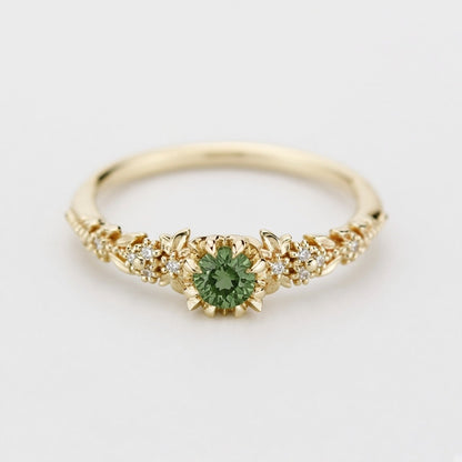 Yellow gold floral engagement ring with a round green sapphire and white diamonds
