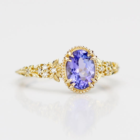 Front view of the Anthea 18k yellow gold ring showcasing a vibrant natural tanzanite and white diamond floral details, 