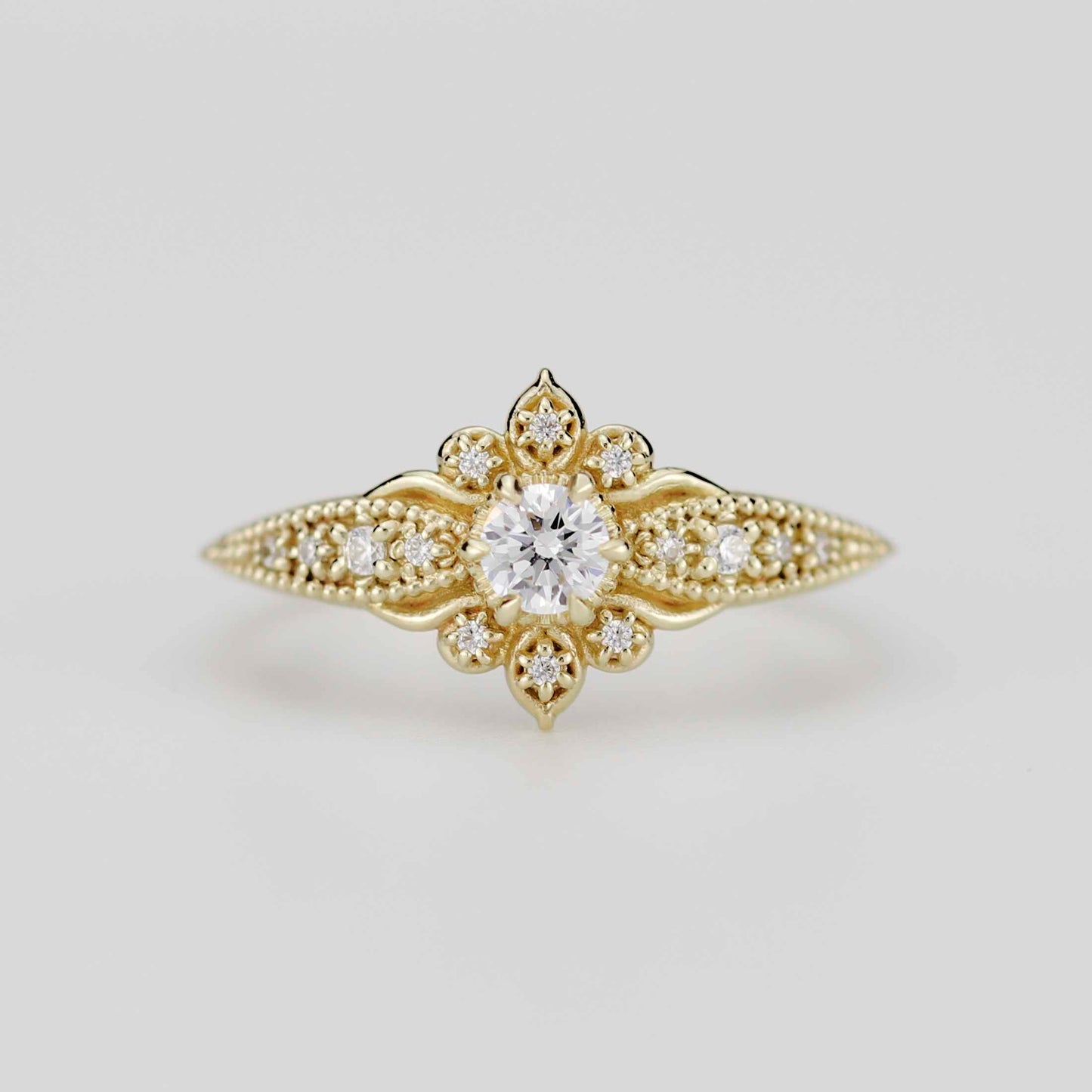 Front view of the Dhalia Mandala ring in 18k solid yellow gold, featuring a center round natural diamond surrounded by a floral mandala cluster and a tapered band with intricate gold granulation.