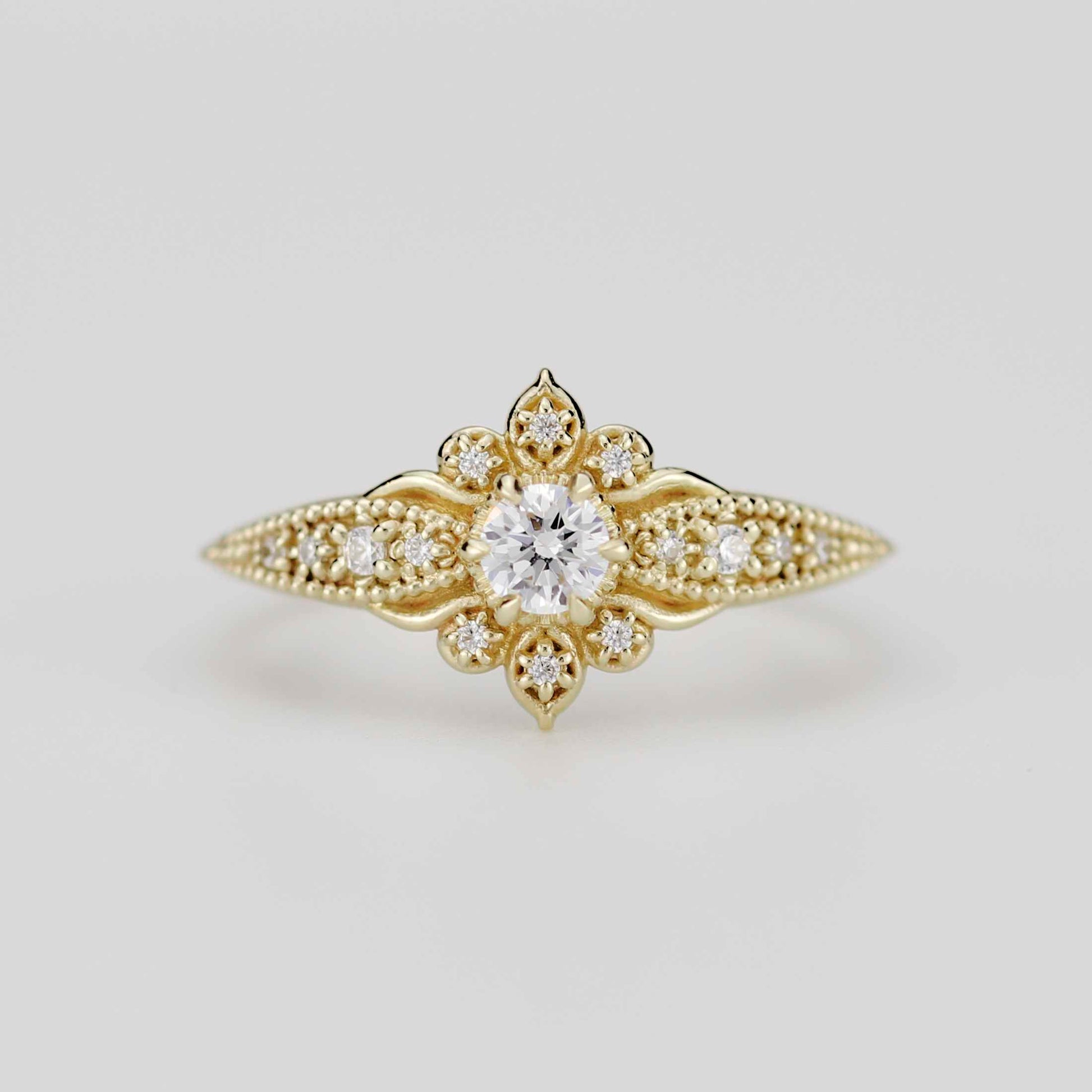 Front view of the Dhalia Mandala ring in 18k solid yellow gold, featuring a center round natural diamond surrounded by a floral mandala cluster and a tapered band with intricate gold granulation.
