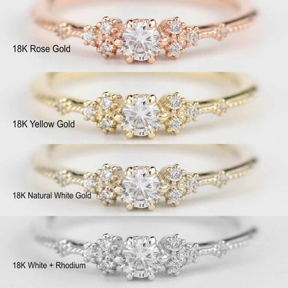Comparison of Nooi Jewelry engagement ring in four metal options: 18K rose gold, 18K yellow gold, 18K natural white gold, and 18K white gold with rhodium plating, each featuring a round center stone with sparkling side diamonds.