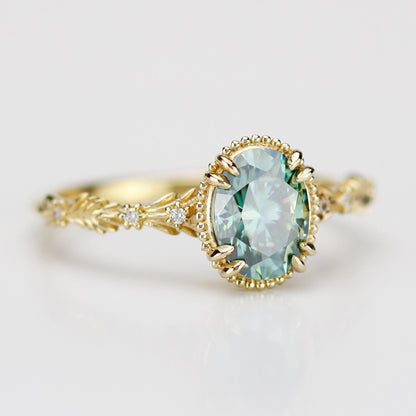 Side view of Rosmaris vintage gold ring featuring an oval green moissanite gemstone in a milgrain bezel with leaf-shaped botanical band and diamonds.