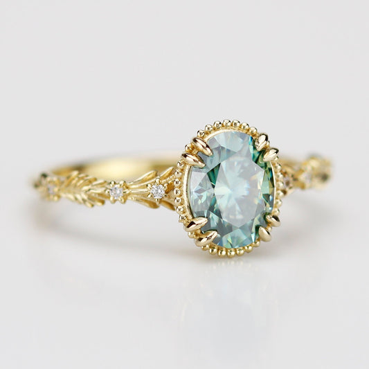 Side view of Rosmaris vintage gold ring featuring an oval green moissanite gemstone in a milgrain bezel with leaf-shaped botanical band and diamonds.