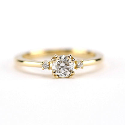 18k gold minimalist ring with a round lab grown diamond, front view on white
