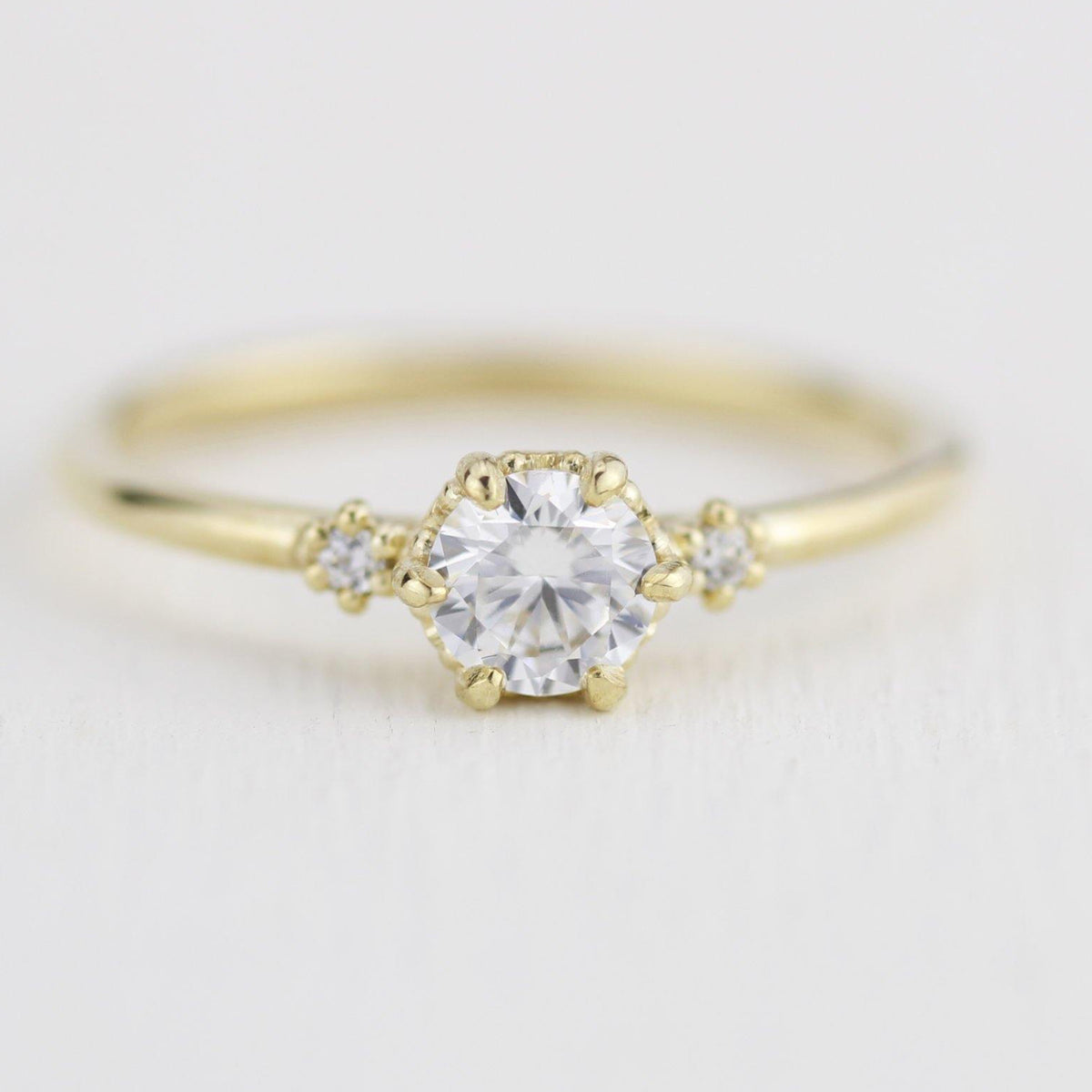 18k gold three stone ring with a half carat, 5 mm round lab grown diamond