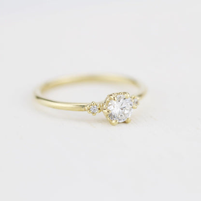 18k gold three stone ring with a round lab grown diamond, angled from the other side