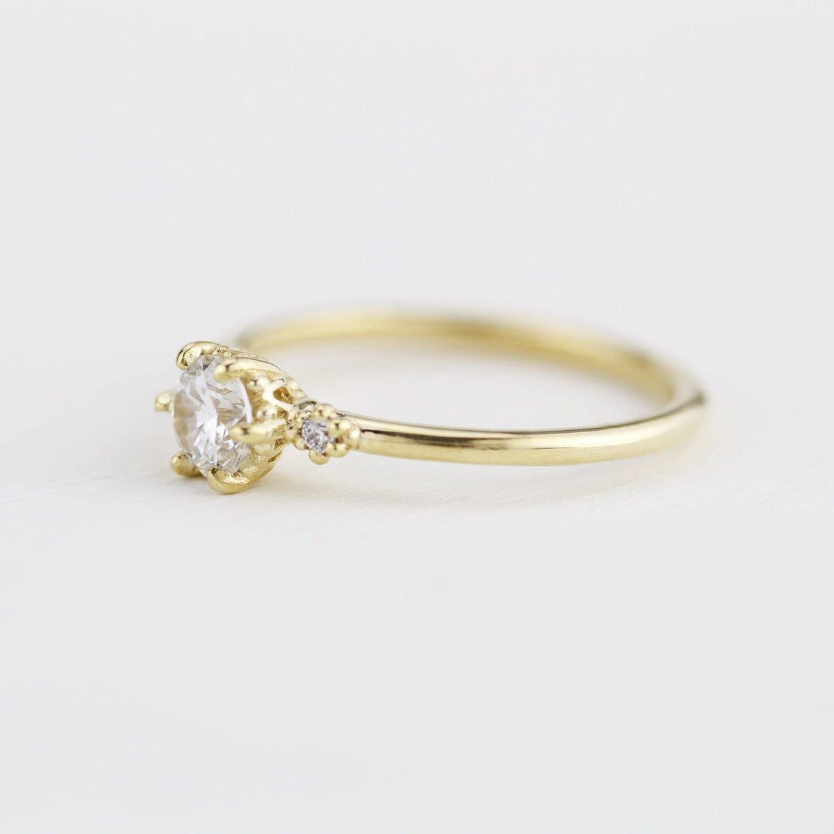 18k gold three stone ring with a round lab grown diamond, side view