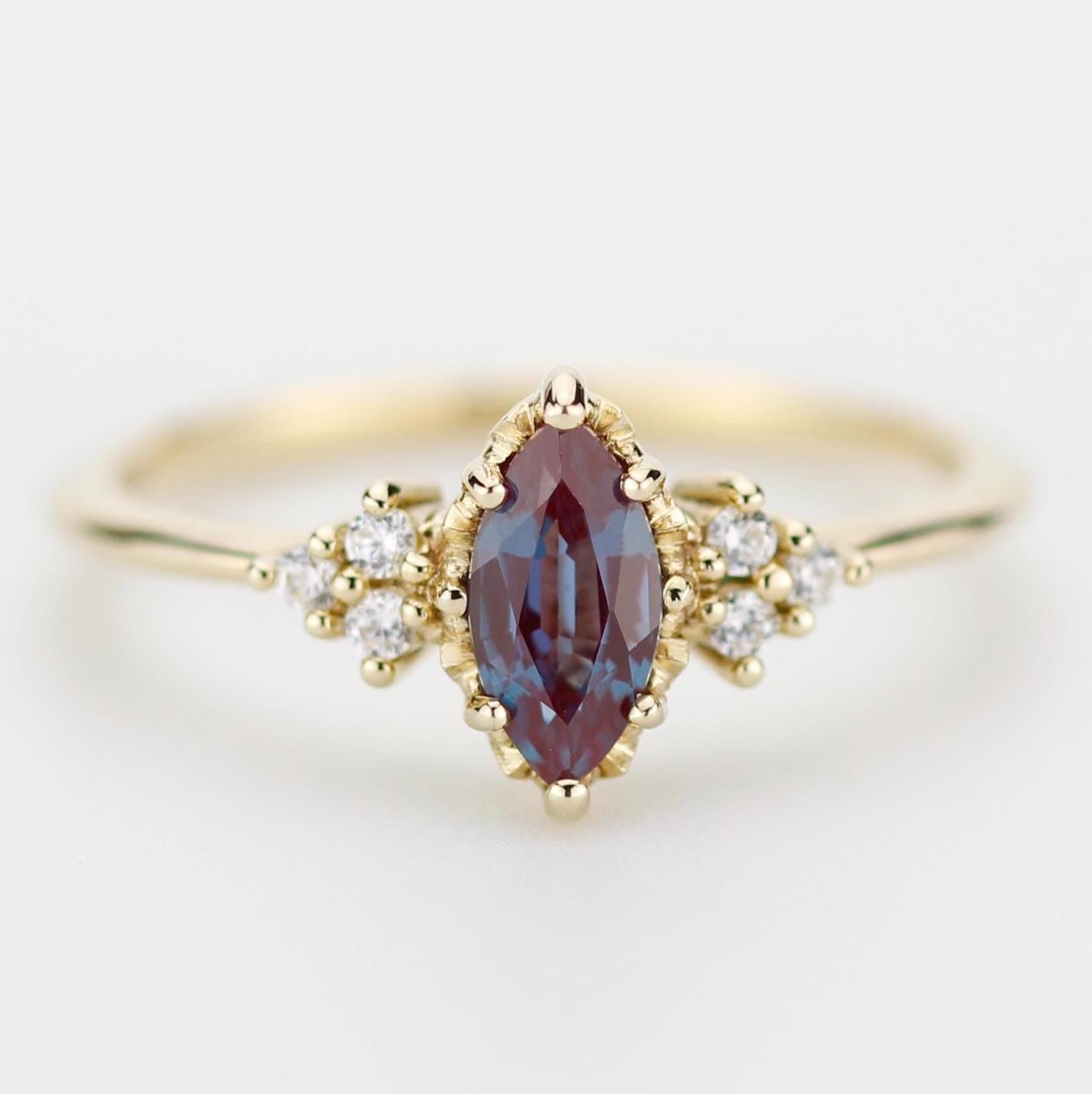 18k solid gold marquise-cut alexandrite and diamond engagement ring featuring a color-changing gemstone that shifts from blue to purple, accented with sparkling diamonds for a luxurious and elegant design.
