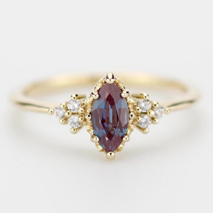 18k solid gold marquise-cut alexandrite and diamond engagement ring featuring a color-changing gemstone that shifts from blue to purple, accented with sparkling diamonds for a luxurious and elegant design.