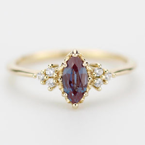 18k solid gold marquise-cut alexandrite and diamond engagement ring featuring a color-changing gemstone that shifts from blue to purple, accented with sparkling diamonds for a luxurious and elegant design.