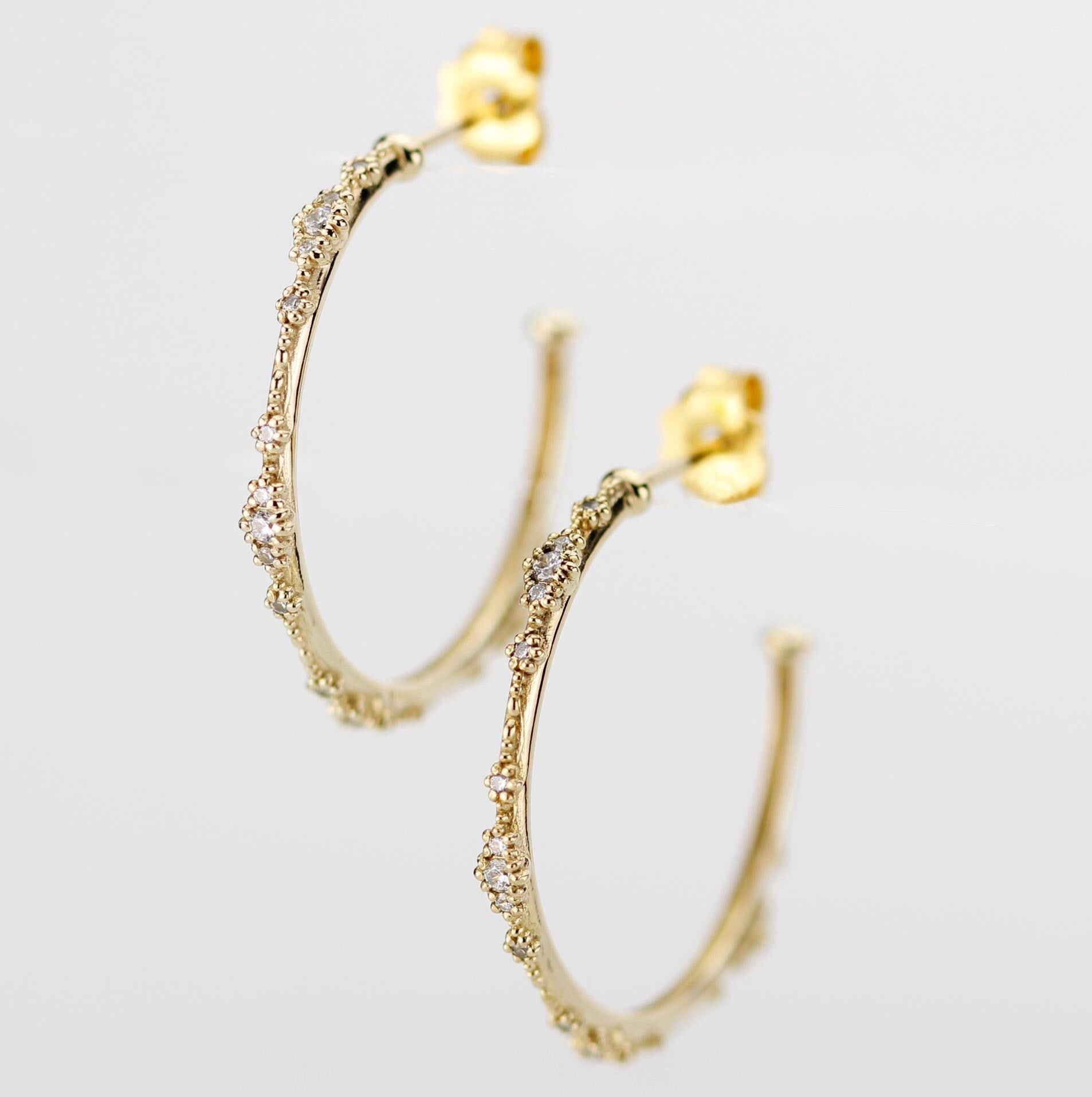Close-up of elegant 18K solid gold hoop earrings with natural diamond accents and delicate beaded detailing, set against a white background. Luxurious fine jewelry for women, perfect for everyday wear or special occasions.
