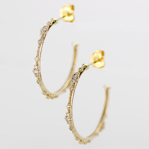 Close-up of elegant 18K solid gold hoop earrings with natural diamond accents and delicate beaded detailing, set against a white background. Luxurious fine jewelry for women, perfect for everyday wear or special occasions.