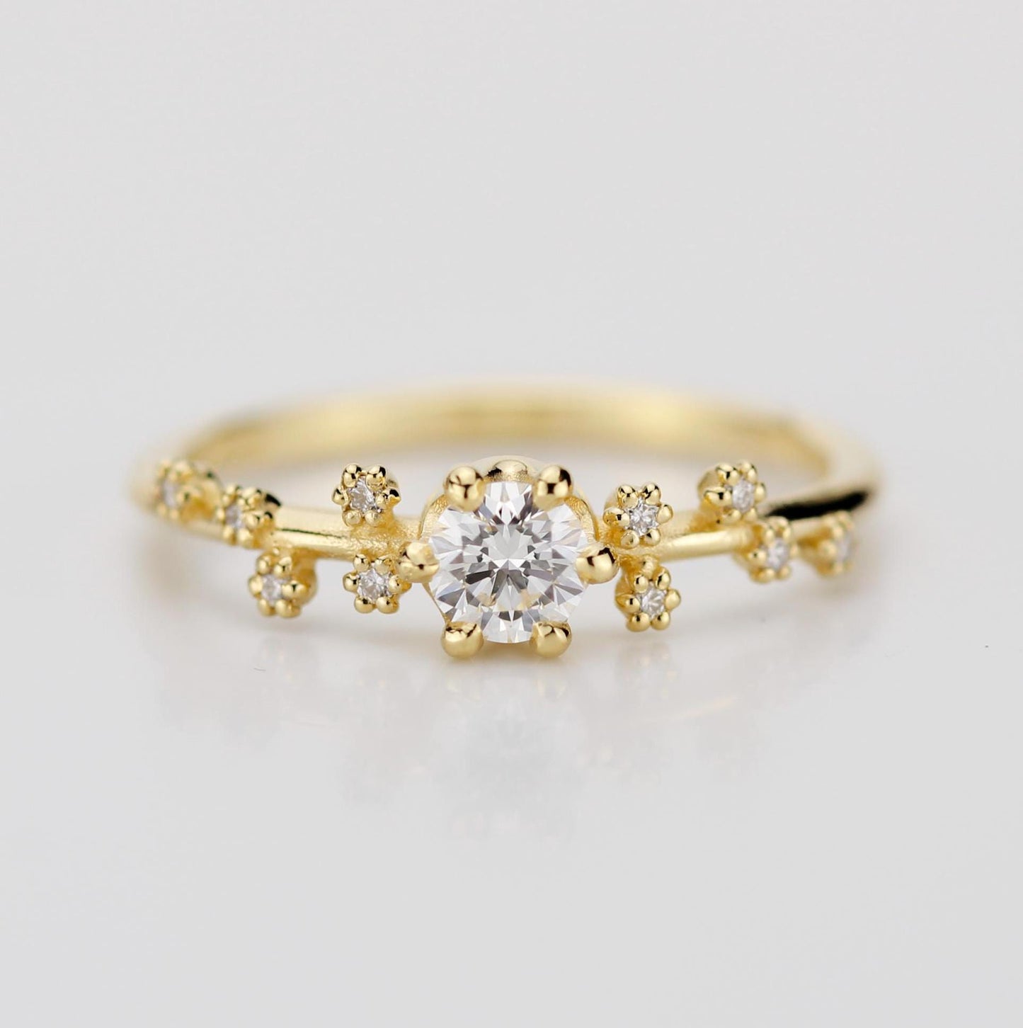 A celestial-inspired 18K gold engagement ring with a 0.25ct natural diamond at the center, accented by diamond side stones arranged in the shape of the Big Dipper constellation, symbolizing guidance and connection to the stars.
