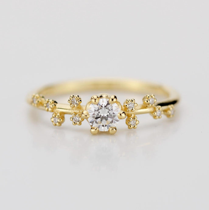 A celestial-inspired 18K gold engagement ring with a 0.25ct natural diamond at the center, accented by diamond side stones arranged in the shape of the Big Dipper constellation, symbolizing guidance and connection to the stars.