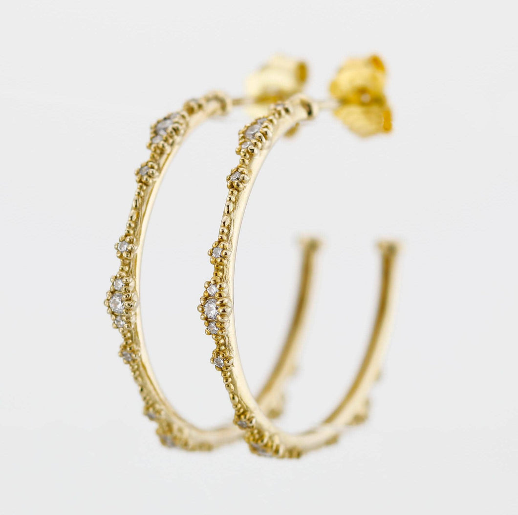Close-up of elegant 18K solid gold hoop earrings with natural diamond accents and delicate beaded detailing, set against a white background. Luxurious fine jewelry for women, perfect for everyday wear or special occasions.