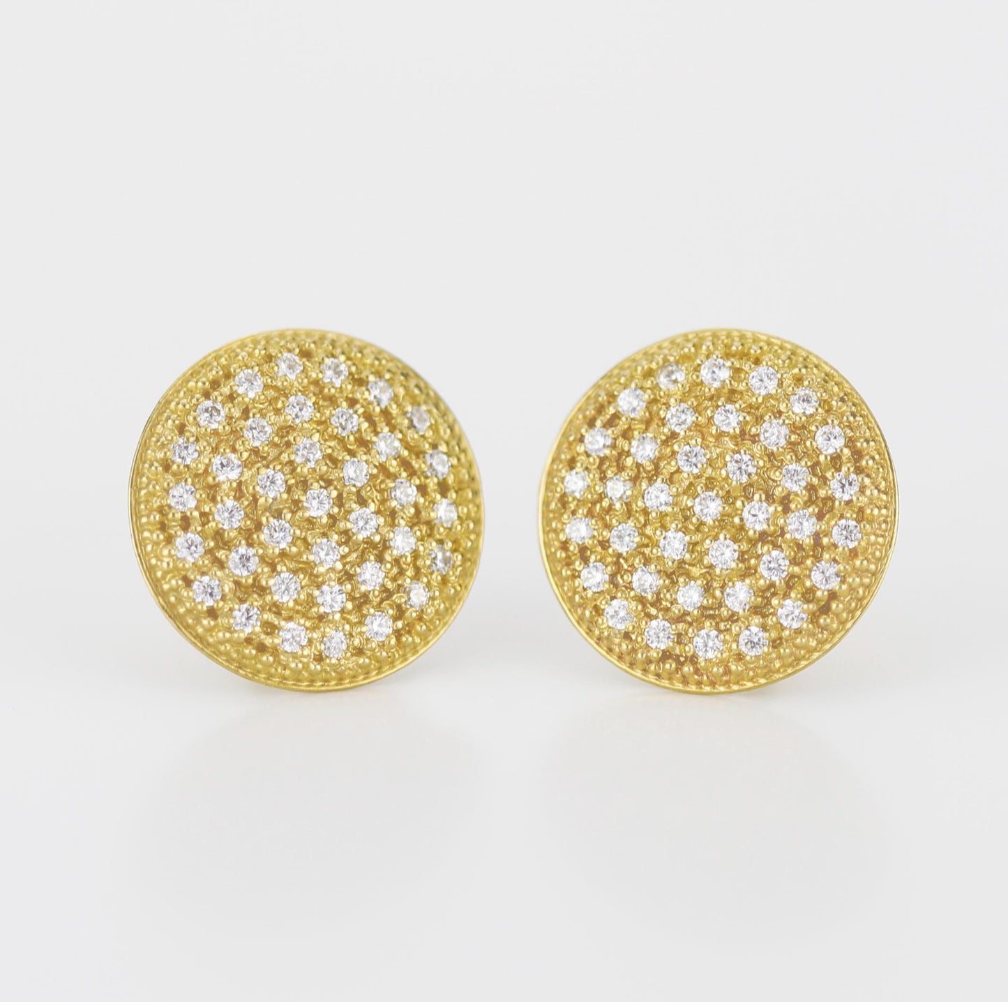 Close-up of elegant 18K solid gold round disk stud earrings, featuring 74 natural 1mm G color VS clarity diamonds in a pave setting, with a butterfly ear back, sparkling against a white background