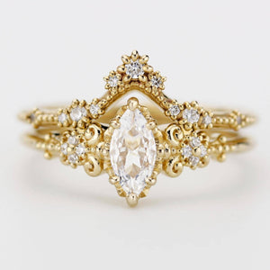 Vintage-inspired marquise moissanite engagement ring with V-shaped diamond wedding band in 18k yellow gold, handcrafted with filigree detailing.
