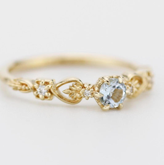 Baroque 18k gold engagement ring featuring a 0.25 ct natural Aquamarine with accent diamonds and vintage-inspired detailing