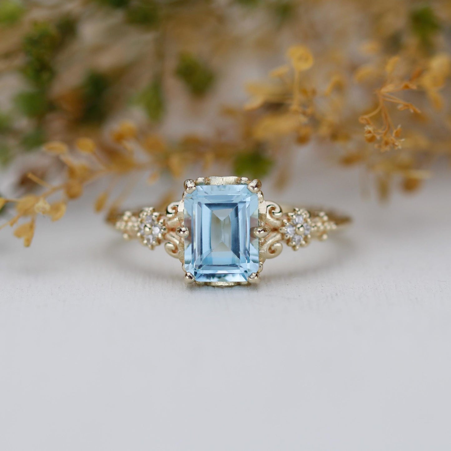 Emerald cut blue gemstone ring set in 18K solid gold with diamond accents and vintage-inspired detailing