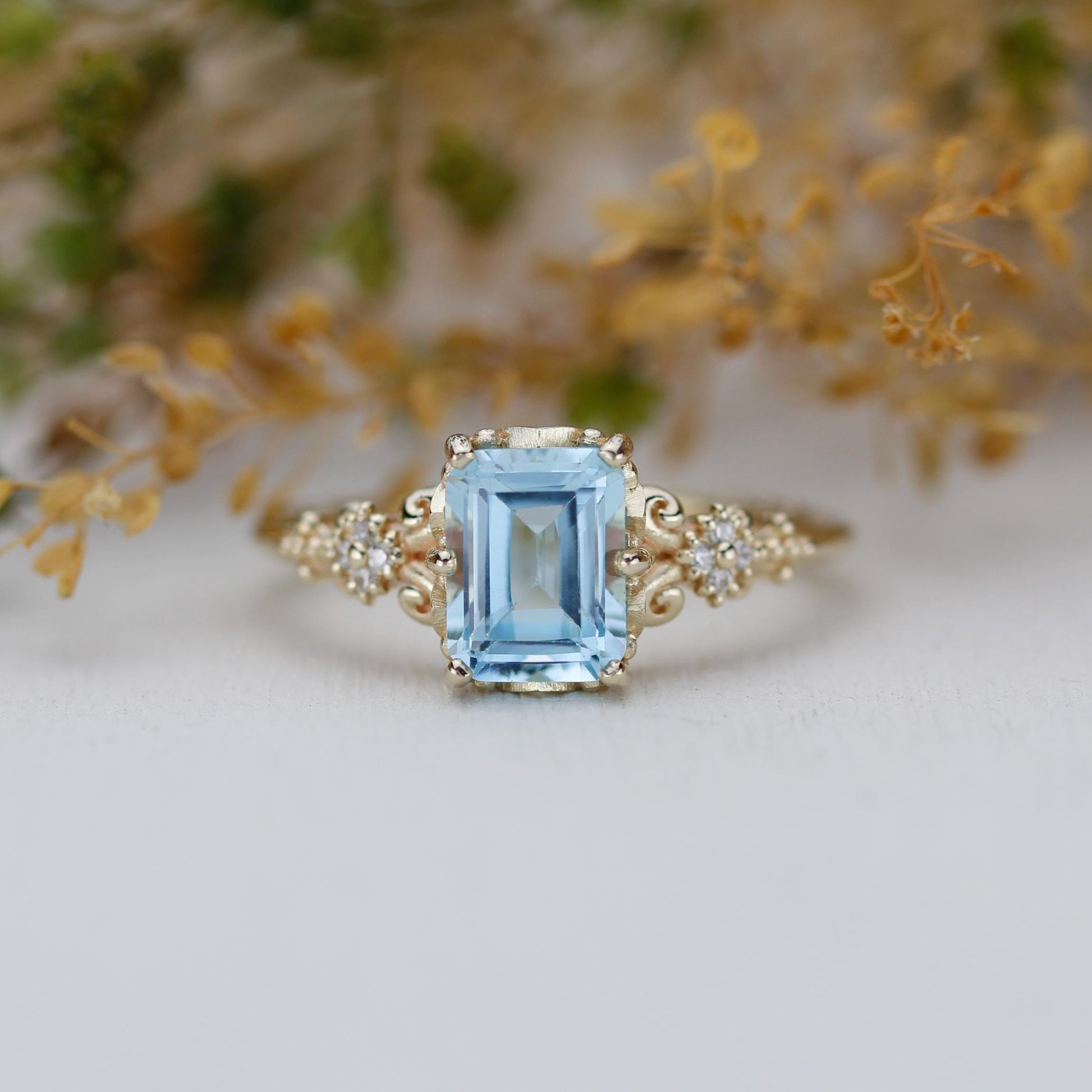 Emerald cut blue gemstone ring set in 18K solid gold with diamond accents and vintage-inspired detailing