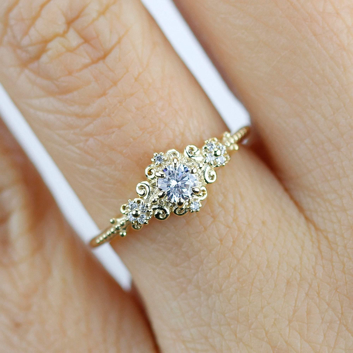 18k gold art deco ring with a round lab grown diamond, worn on the hand