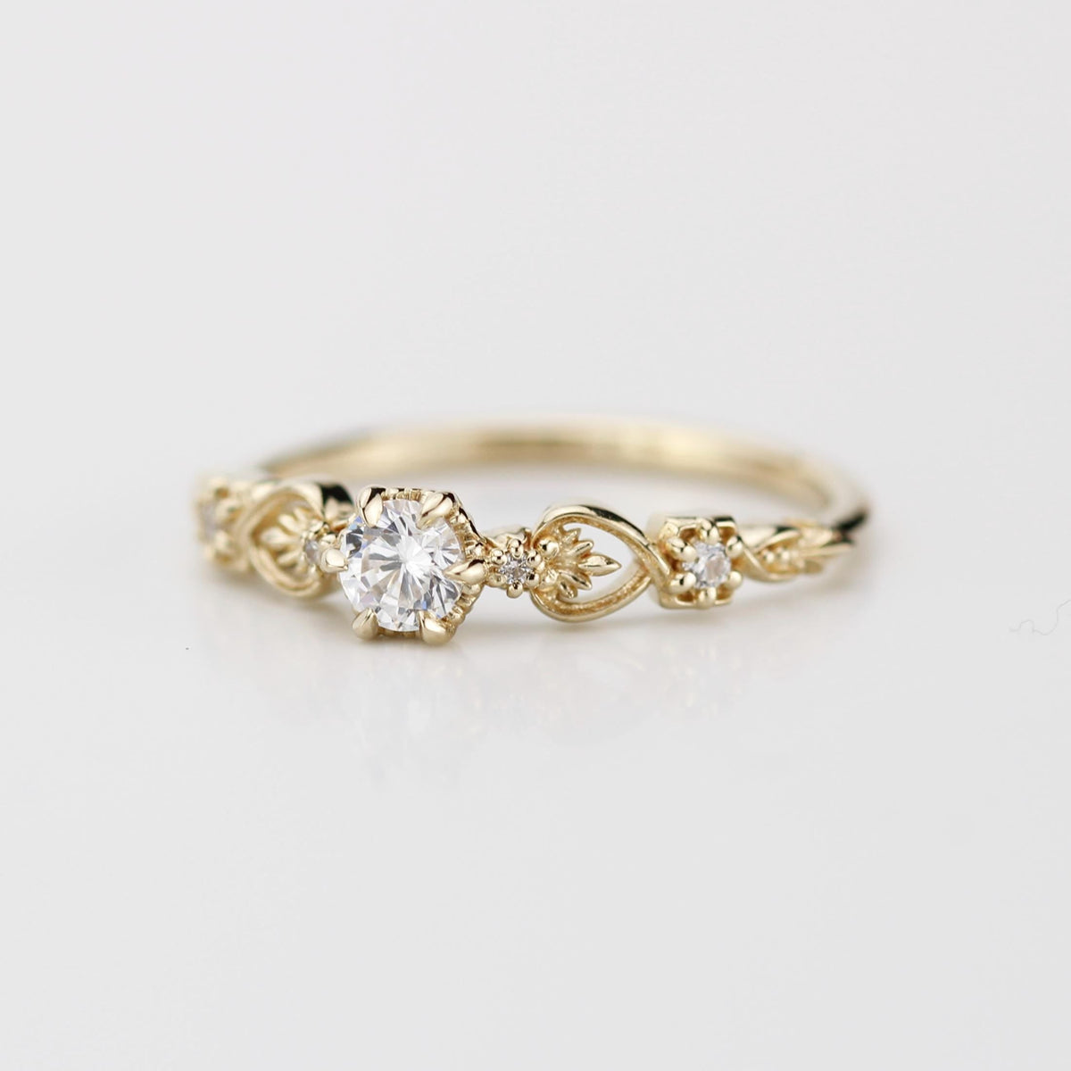 18k gold baroque scroll ring with a round lab grown diamond, angled view