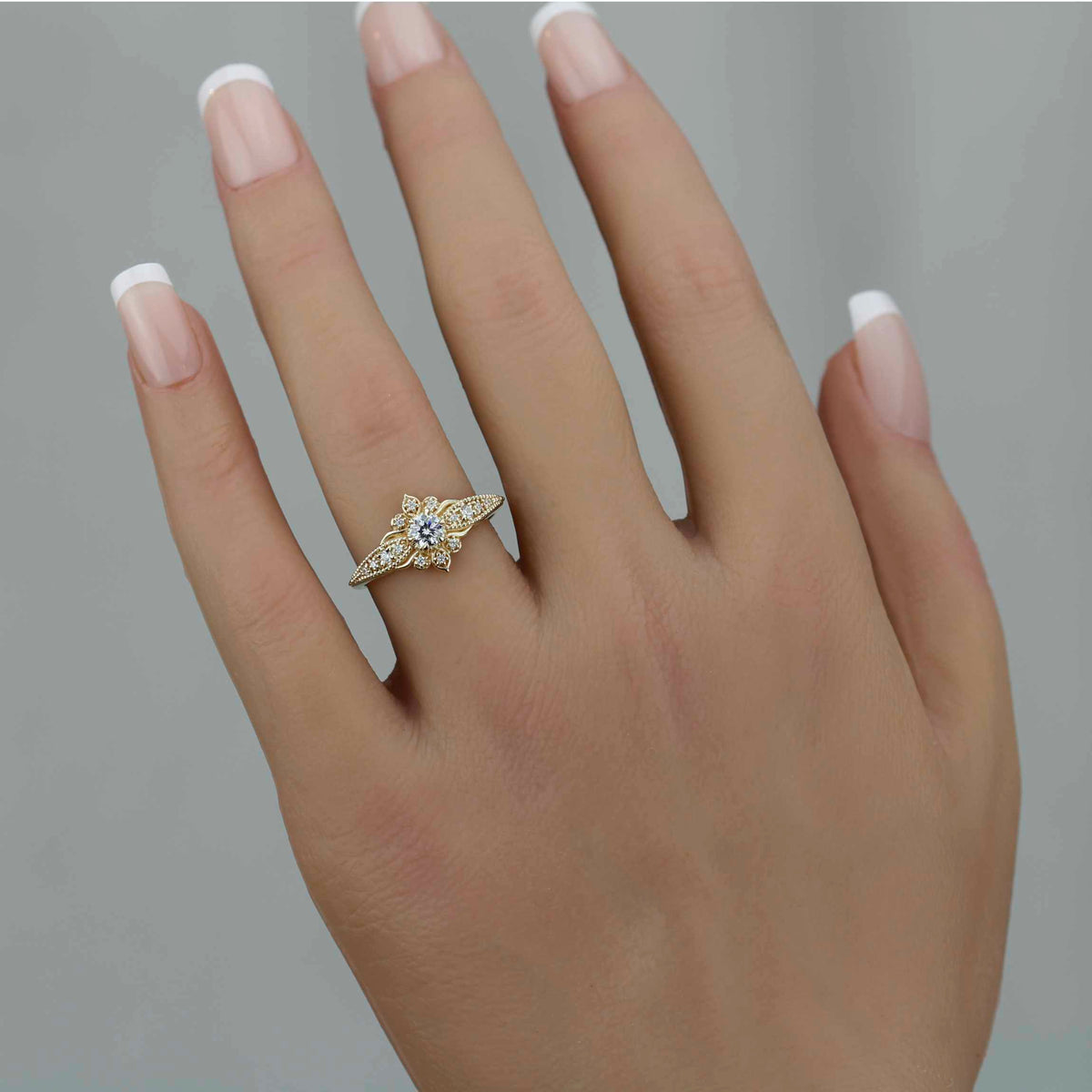 18k gold Dhalia ring with a round lab grown diamond, worn on the hand, farther view