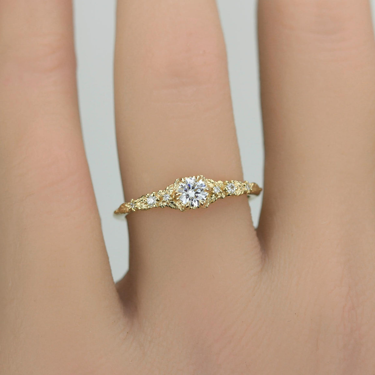 18k gold milgrain leaf ring with a round lab grown diamond, worn on the hand