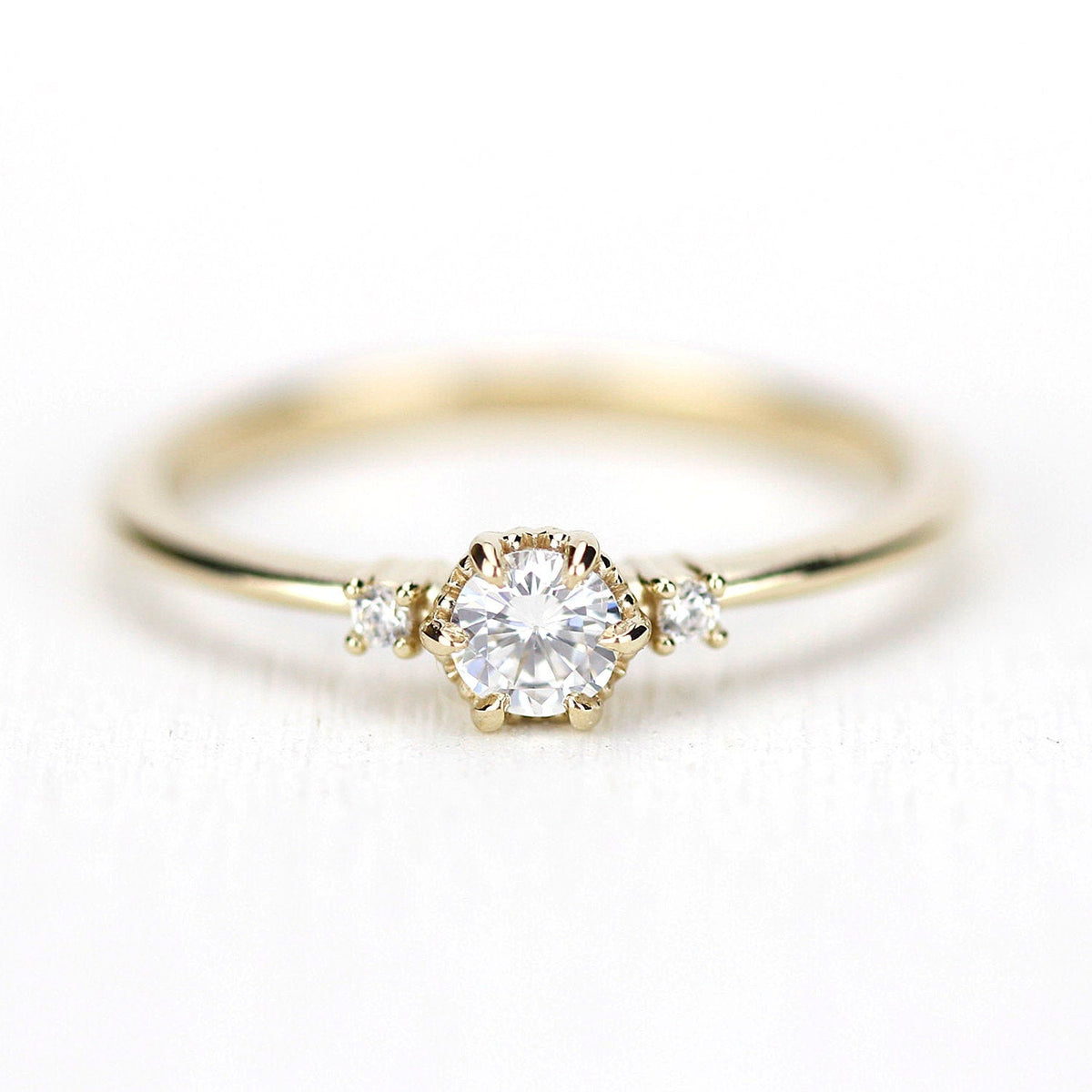 18k gold three stone ring with a 4 mm round lab grown diamond