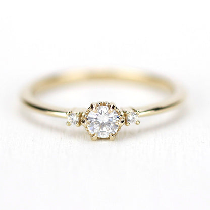 18k gold three stone ring with a 4 mm round lab grown diamond