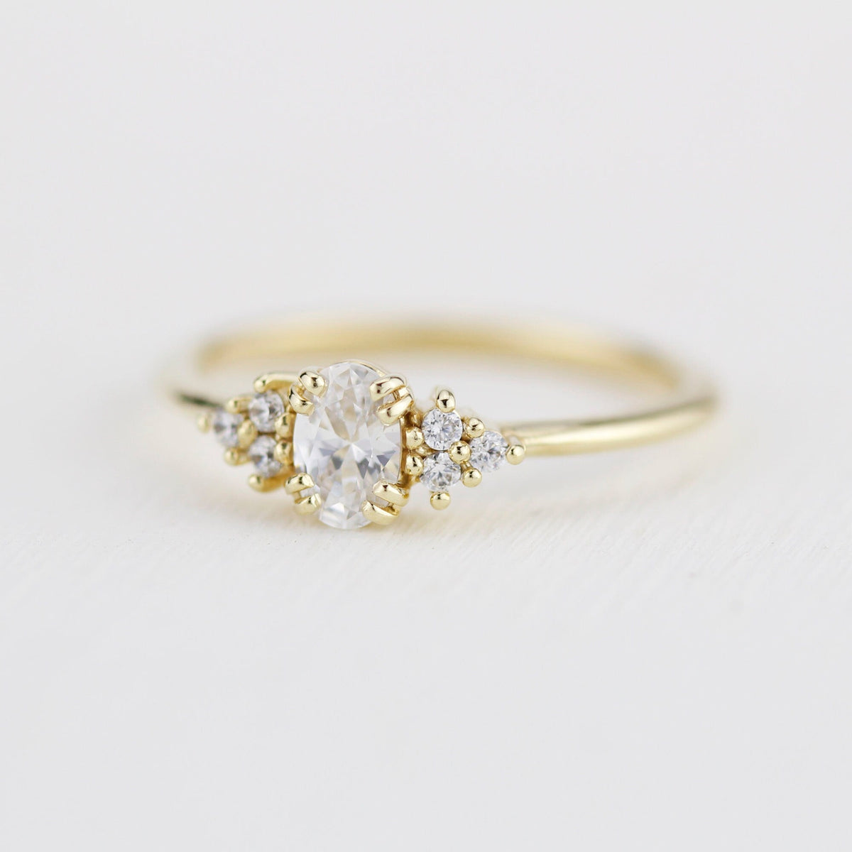18k gold cluster ring with an oval lab grown diamond, angled view