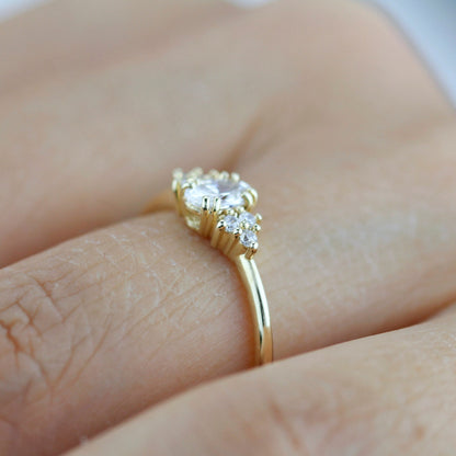 18k gold cluster ring with an oval lab grown diamond, worn on the hand, side view