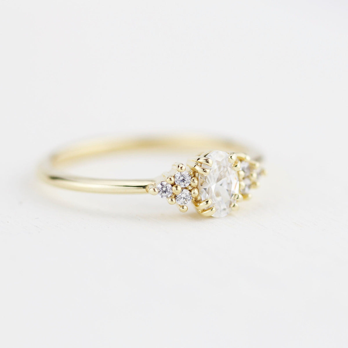 18k gold cluster ring with an oval lab grown diamond, side view