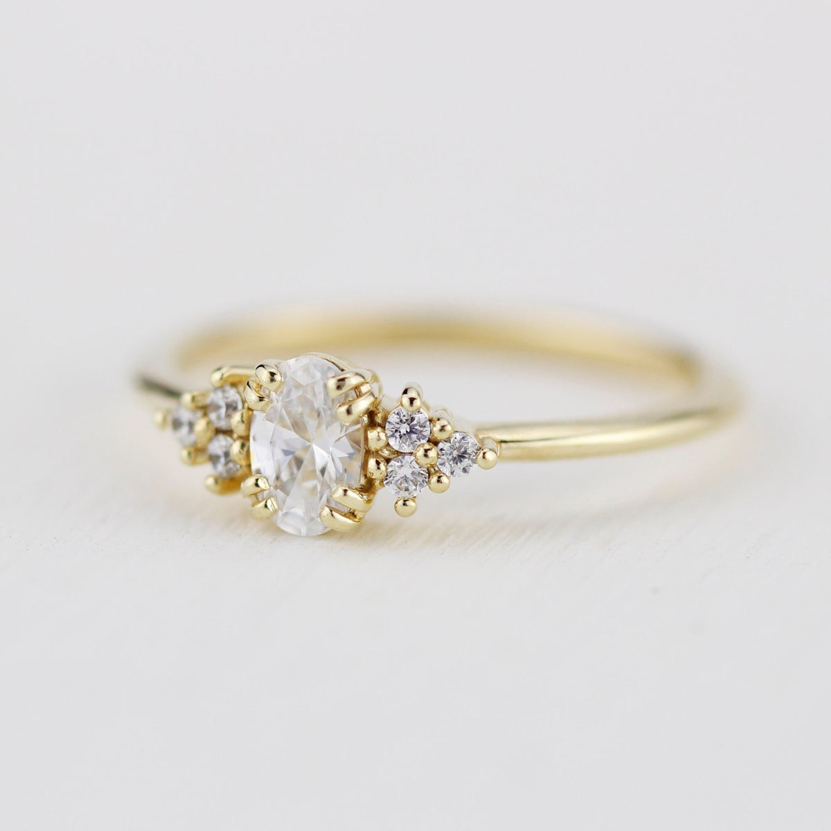 18k gold cluster ring with an oval lab grown diamond, three-quarter view