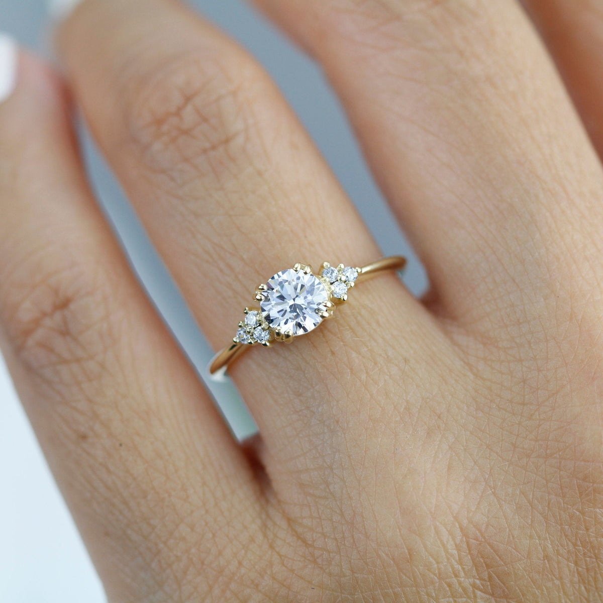 18k gold split-prong ring with a round lab grown diamond, worn on the hand