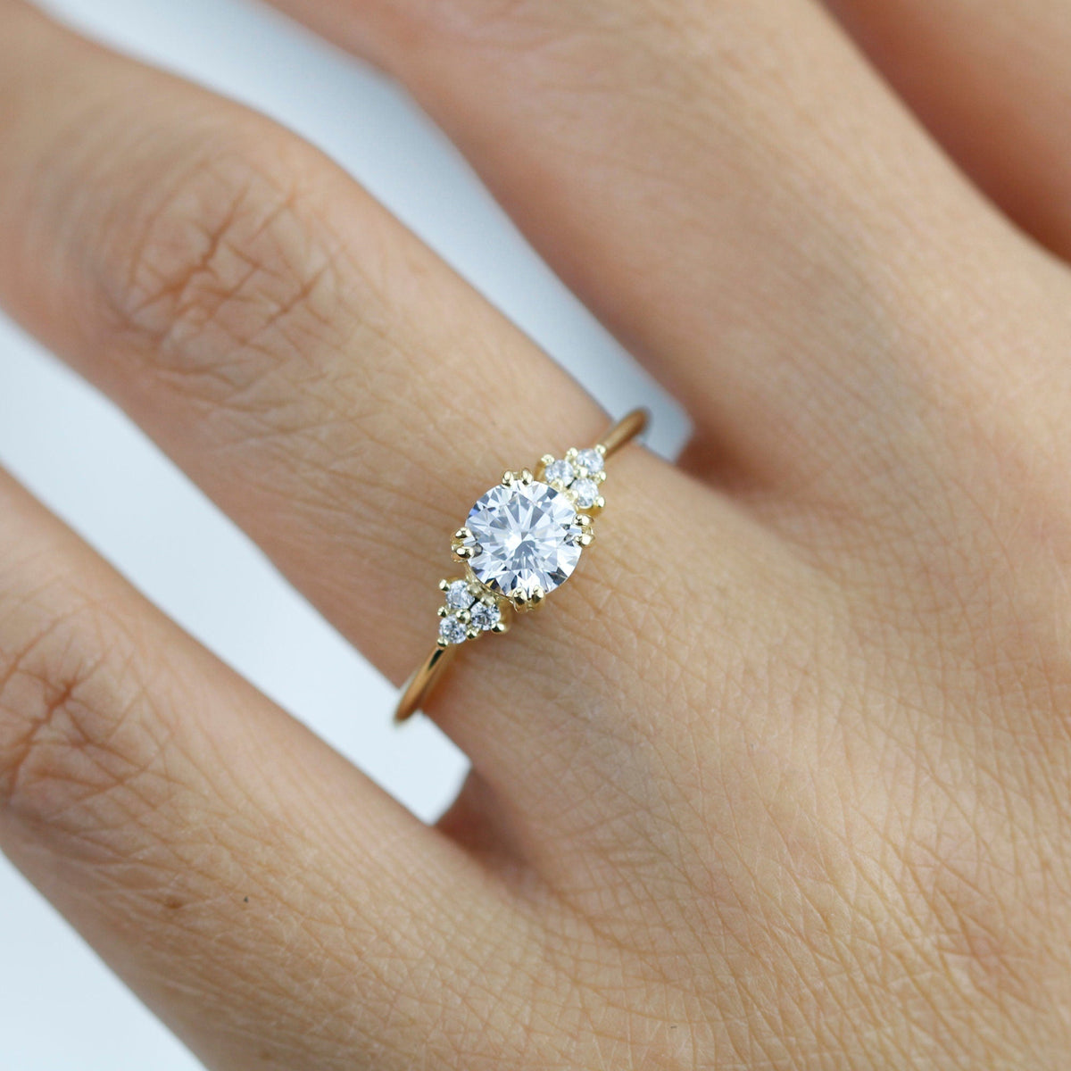 18k gold split-prong ring with a round lab grown diamond, worn on the hand, close view