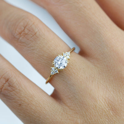 18k gold split-prong ring with a round lab grown diamond, worn on the hand, close view